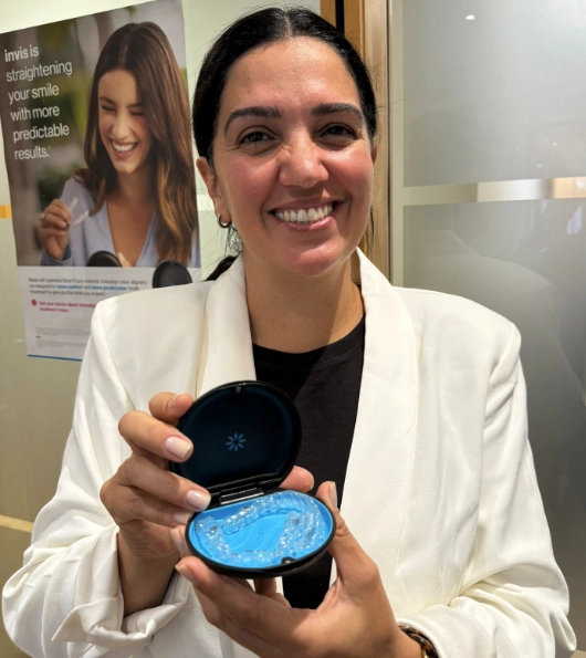 Dr. Sara Flanagan from Enhance Dental holding an Invisalign aligner model in Dublin clinic.
